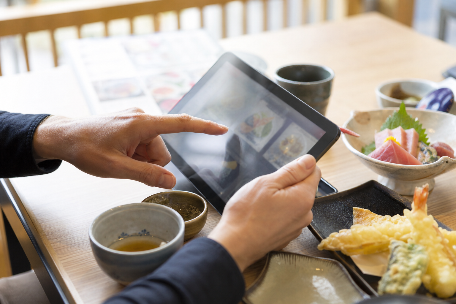 タブレットの多言語メニューを見る外国人観光客